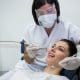 dentist-examining-a-female-patient-with-tools-at-dental-clinic