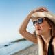 beautiful-young-cheerful-girl-in-hat-and-sunglasses-rests-at-morning-beach