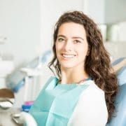 portrait-smiling-young-woman-sitting-chair-dental-clinic